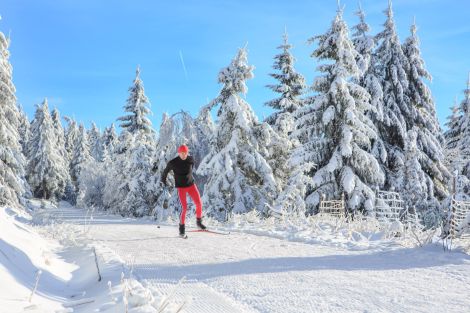 Mann beim Langlaufen in einer verschneiten Winterlandschaft