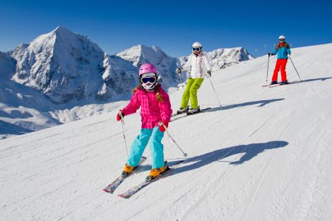 Familie beim Skifahren in den Alpen